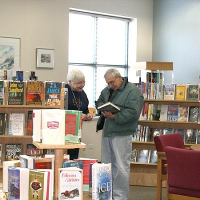 photo of staff and customer in senior center reading room