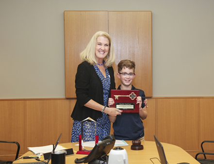 Contest winner holding key to the library with Library Board President