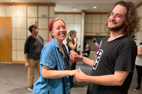 Young adults salsa dancing at library program