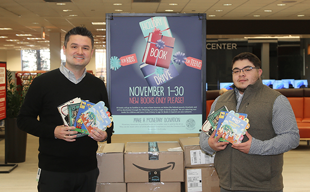 Library staff and Wheeling Township holding donated Holiday Book Drive books at the library