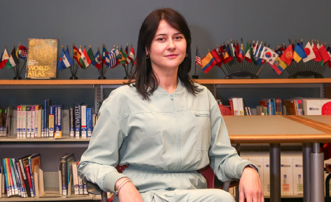 Olena Yarema sits on a chair in the ESL & Literacy Services Office.