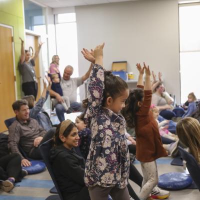 Families follow an action rhyme together at Family Time