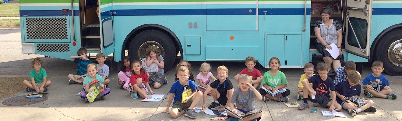Photo of Bookmobile with kids on sidewalk out front
